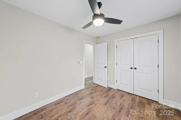 a view of an empty room with wooden floor