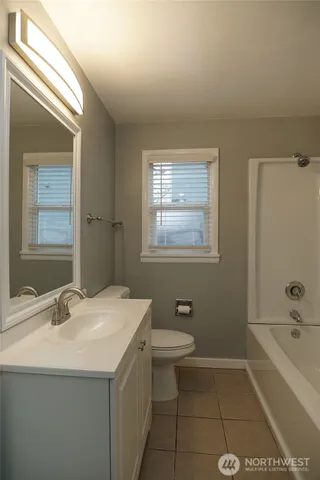 a bathroom with a tub sink toilet and mirror