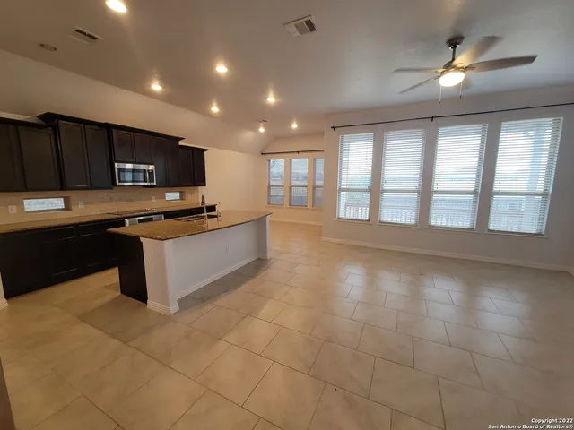 a large kitchen with stainless steel appliances a stove a sink and a microwave