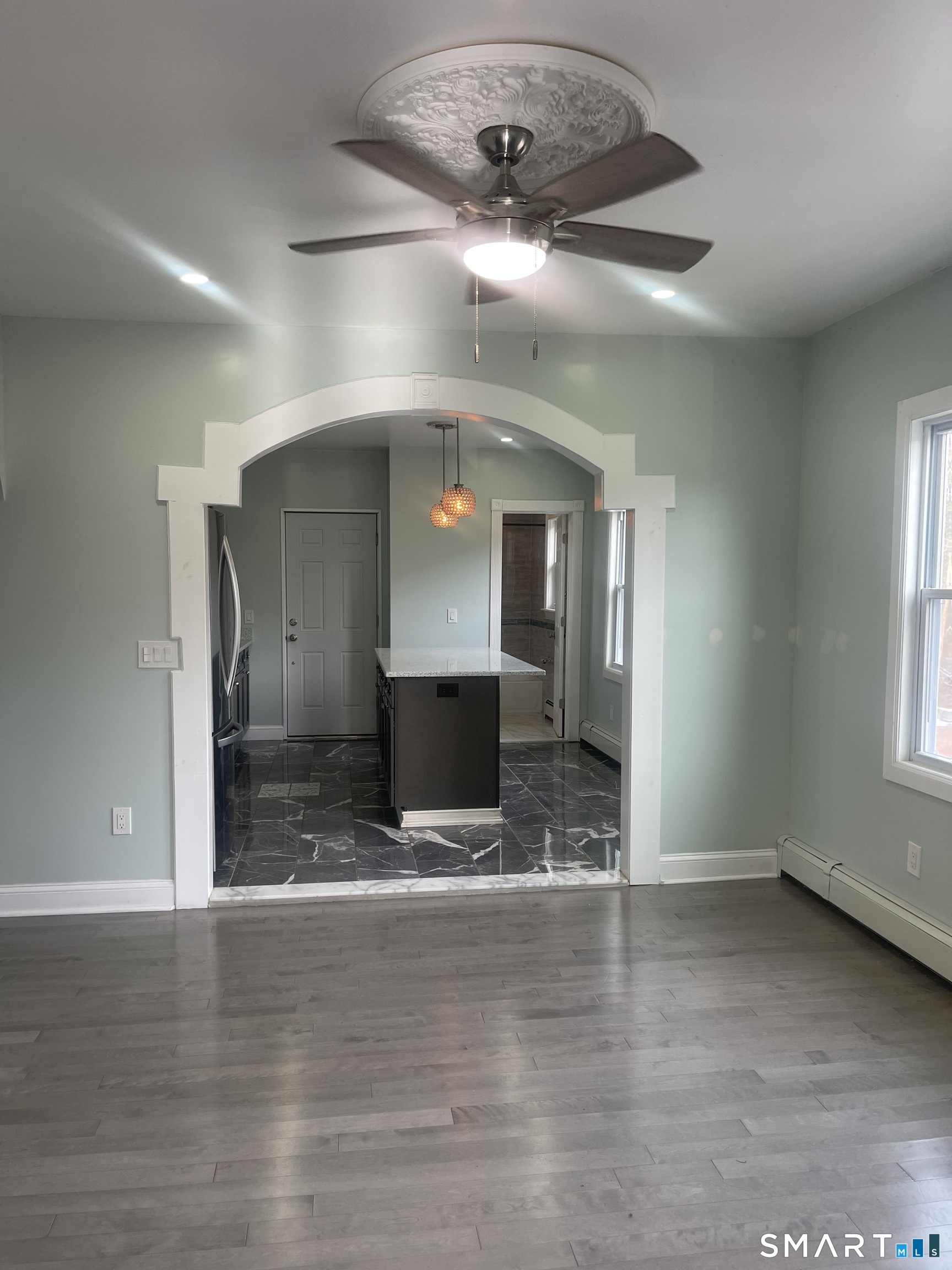 176 Pearl Street Waterbury, CT 06704 - Photo 17 of 19 an empty room with wooden floor and kitchen view