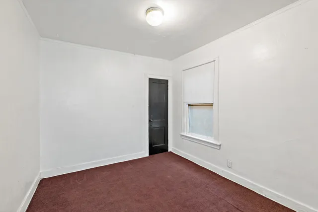 an empty room with closet and windows