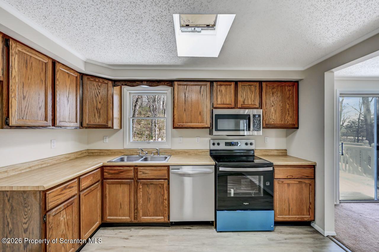 3032 1/2 Division Street Scranton, PA 18504 - Photo 19 of 49 a kitchen with stainless steel appliances a stove sink microwave and cabinets