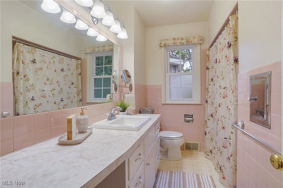 449 East Comet Road Clinton, OH 44216 - Photo 28 of 39 1st Flr Bathroom featuring curtained shower, tile walls, vanity, and toilet