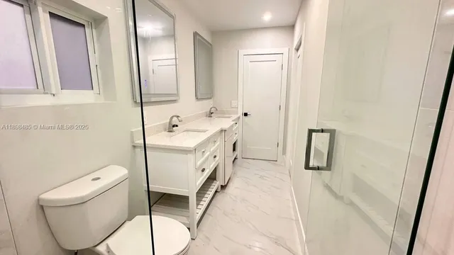 a bathroom with a sink a toilet and mirror