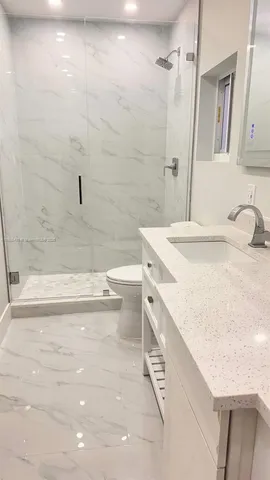 a bathroom with a sink a vanity and shower