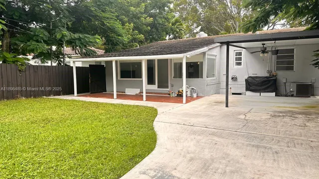 a view of a house with backyard and sitting area