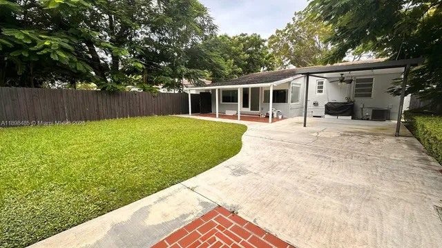 a backyard of a house with table and chairs