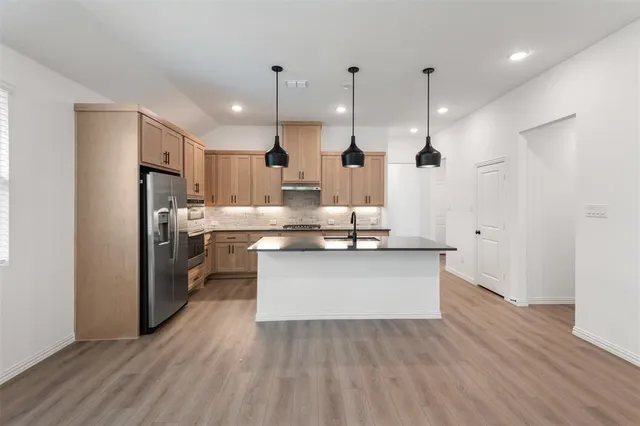 a kitchen with kitchen island a sink appliances and cabinets