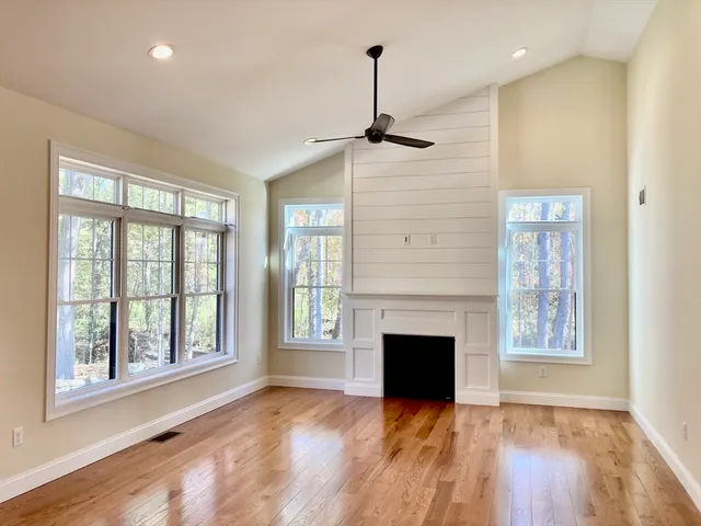 a view of empty room with a fireplace and wooden floor