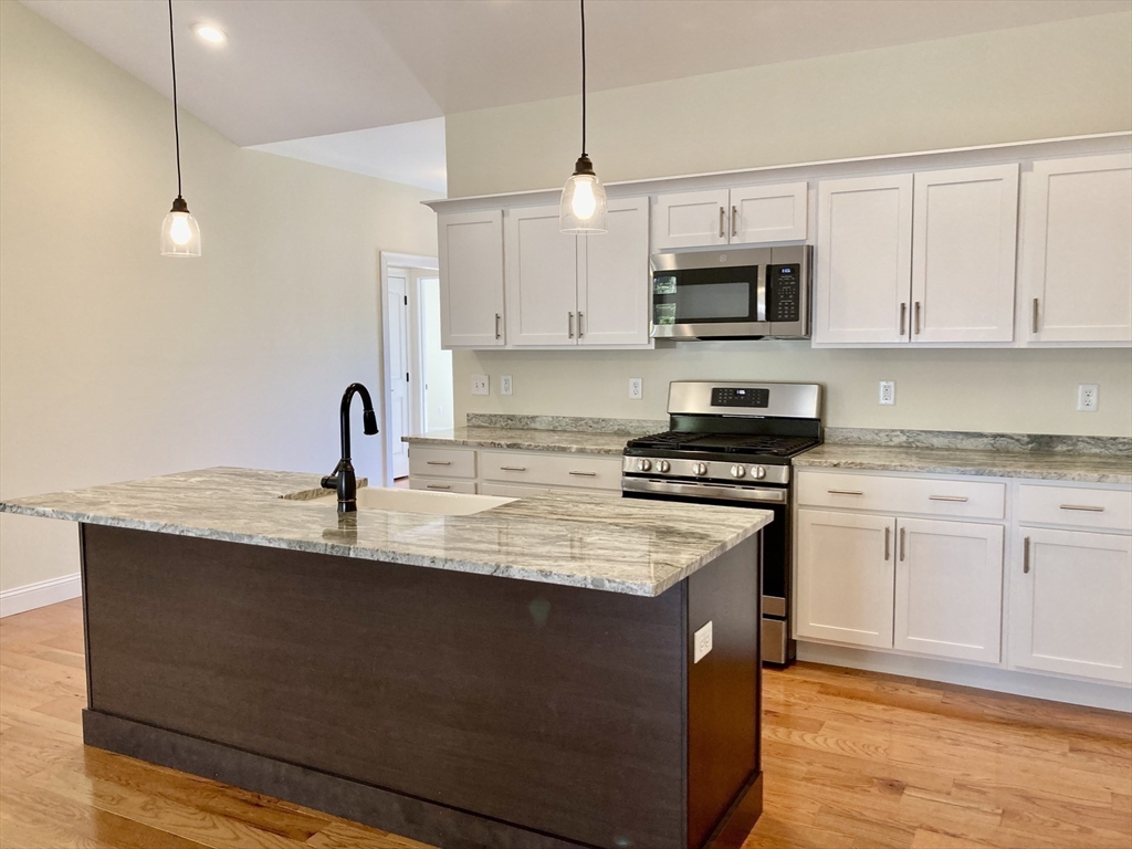 28 Spring Street Petersham, MA 01366 - Photo 11 of 31 a kitchen with stainless steel appliances granite countertop a sink a stove a refrigerator a microwave oven with white cabinets