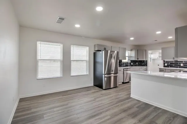 a kitchen with stainless steel appliances a refrigerator and a stove top oven