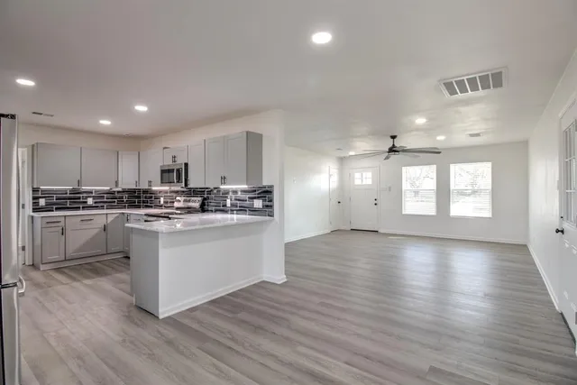 a view of a kitchen with electric appliances and cabinets
