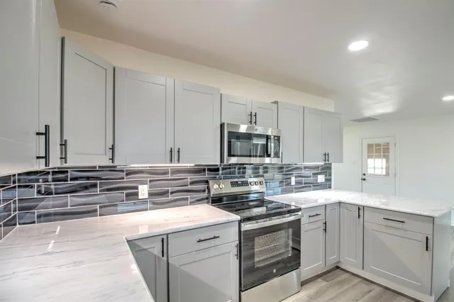 a kitchen with stainless steel appliances a sink stove and cabinets