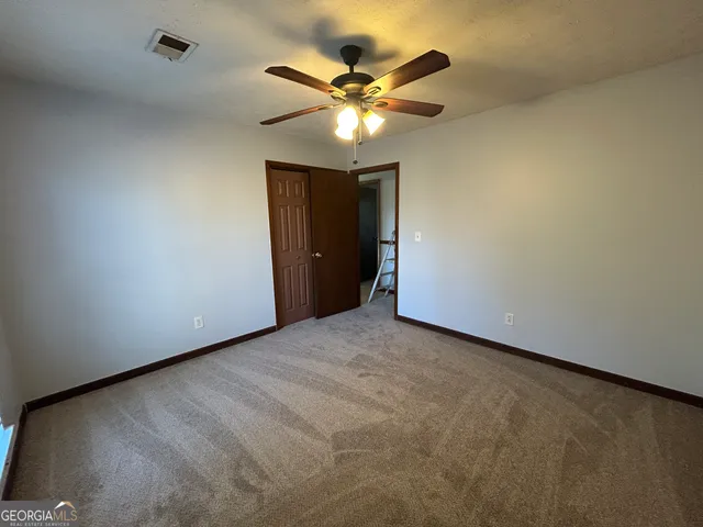 a view of an empty room with a ceiling fan