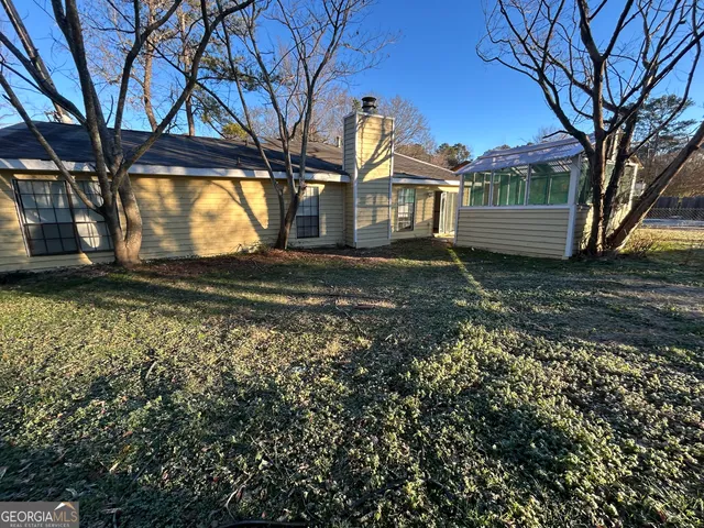 a view of a yard with plants and a tree