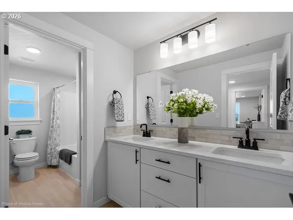 a bathroom with a double vanity sink mirror and toilet
