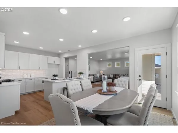 a kitchen with a dining table chairs and view living room