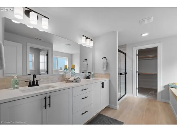 a bathroom with a sink a toilet and a large mirror