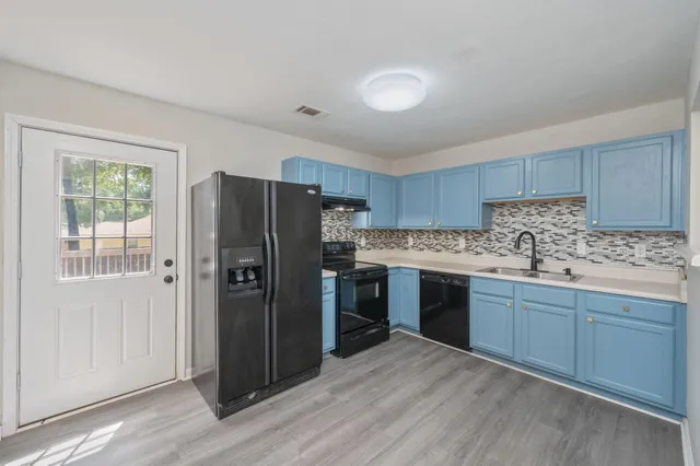 a kitchen with stainless steel appliances granite countertop a refrigerator stove and sink