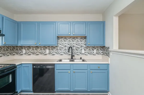 a kitchen with cabinets appliances and a sink