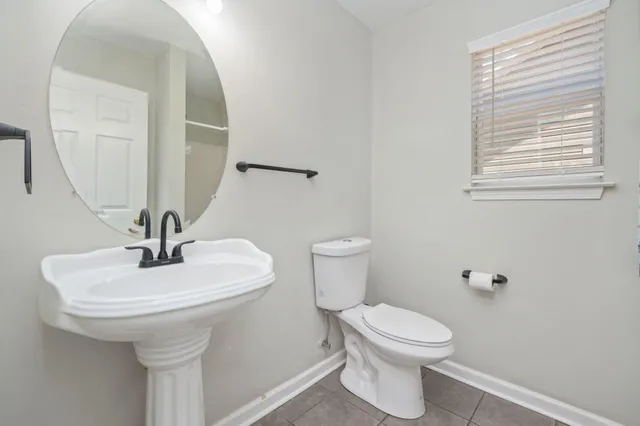 a bathroom with a toilet a sink and a mirror