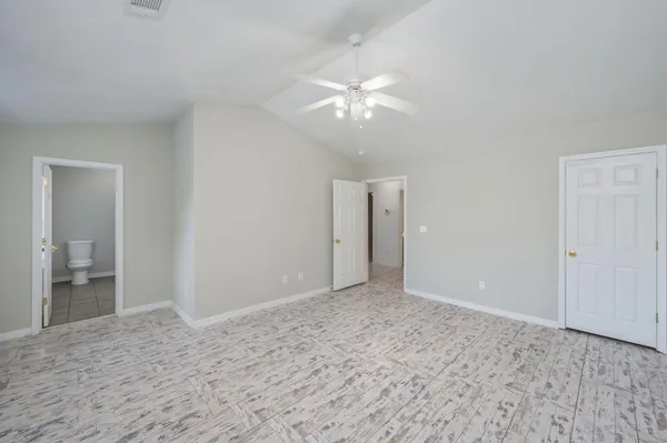 a view of an empty room with a chandelier fan