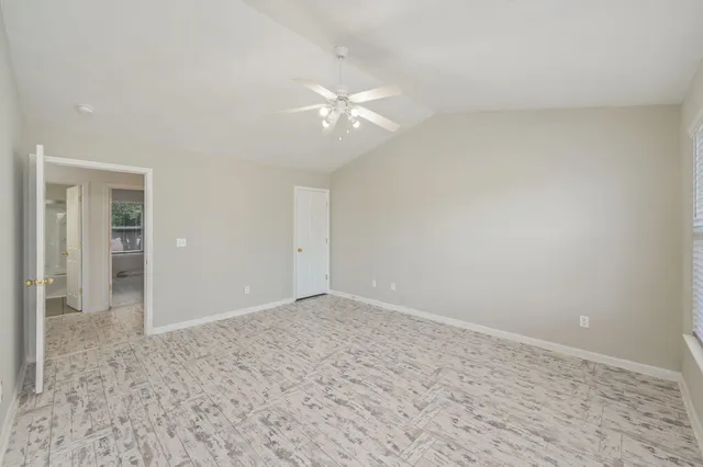 an empty room with closet and a ceiling fan
