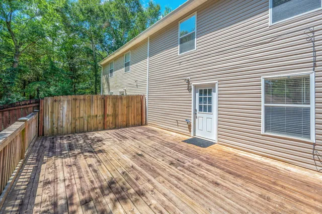 a view of backyard with wooden fence and large trees