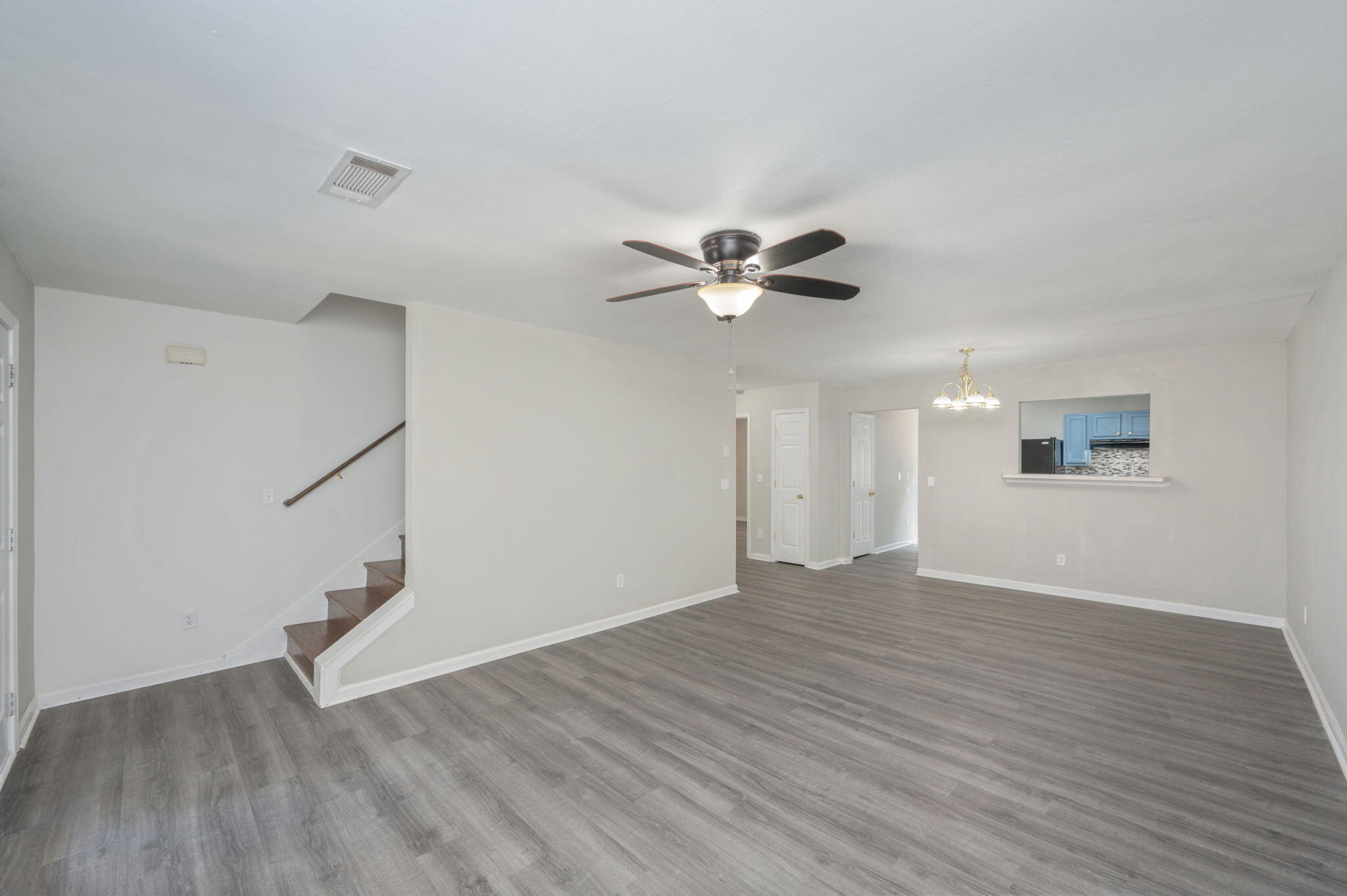 242 Wainwright Drive Crestview, FL 32539 - Photo 7 of 43 a view of an empty room with wooden floor and a ceiling fan