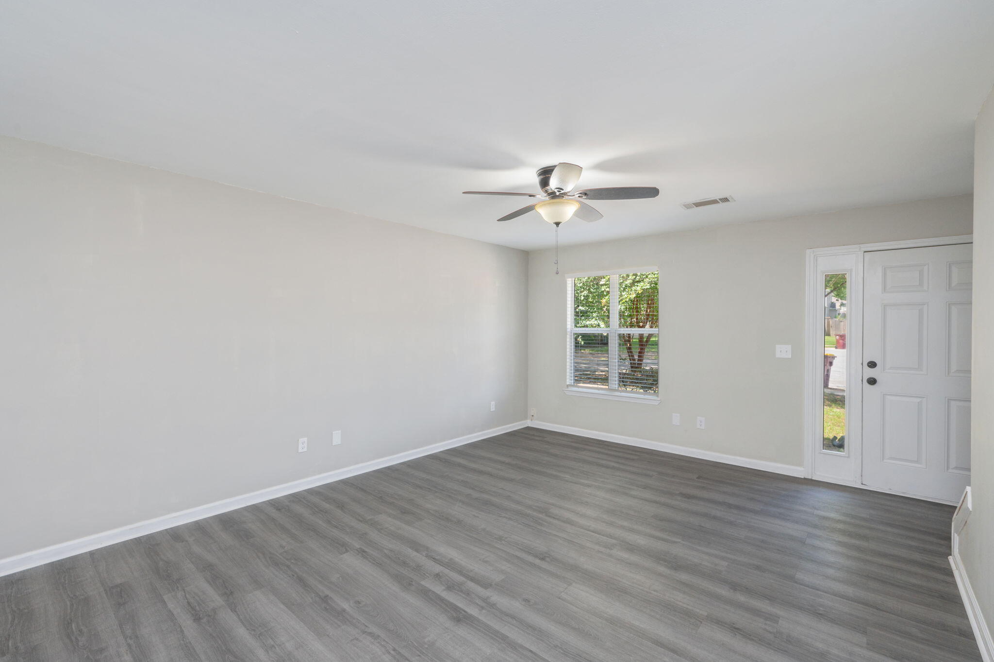 242 Wainwright Drive Crestview, FL 32539 - Photo 9 of 43 wooden floor in an empty room with a window