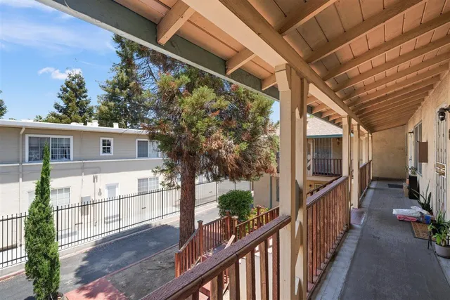 a view of balcony with wooden floor and fence