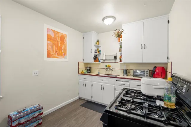 a kitchen with granite countertop white cabinets and white appliances