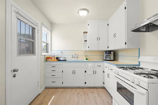 a kitchen with refrigerator a stove a cabinets and window