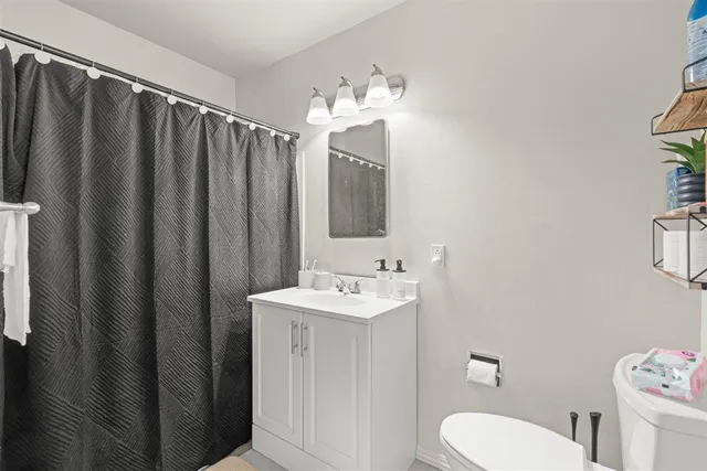 a bathroom with a sink a toilet and shower curtain