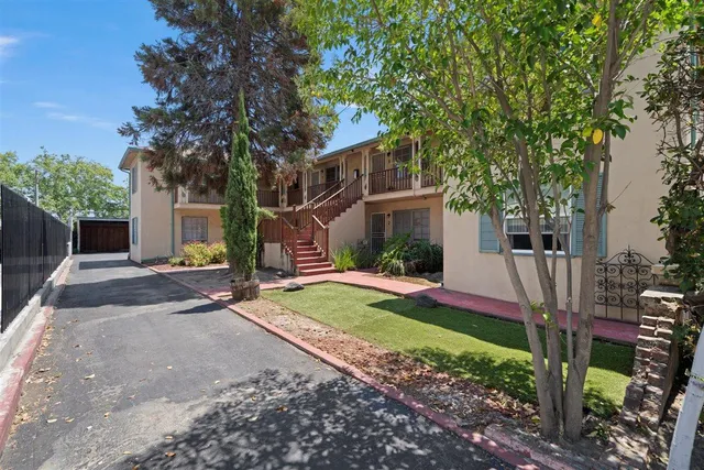 a view of a house with a yard and large tree