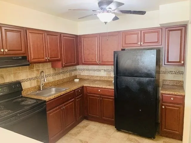 a kitchen with a refrigerator sink and cabinets