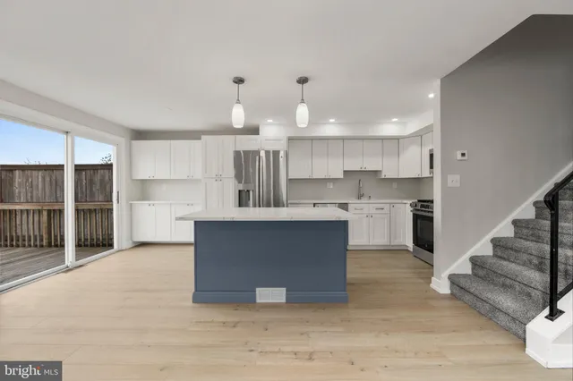 a open kitchen with kitchen island a sink dishwasher a stove and a refrigerator with wooden floor