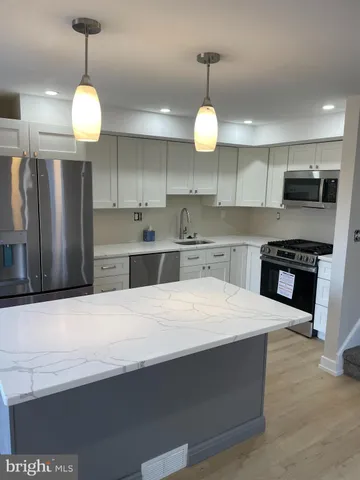 a large kitchen with stainless steel appliances a large center island attached withe stove