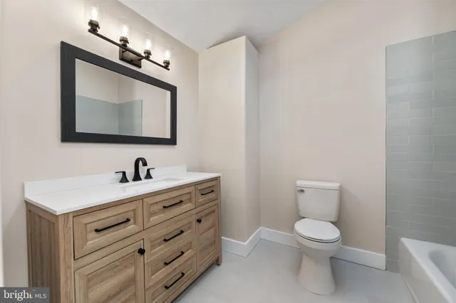 a bathroom with a toilet sink vanity and mirror
