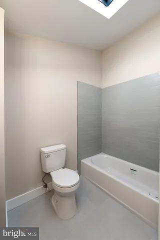 a white toilet sitting next to a bath tub