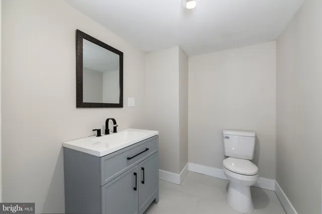 a bathroom with a toilet a sink and mirror