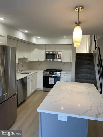 a kitchen with stainless steel appliances a stove refrigerator and cabinets