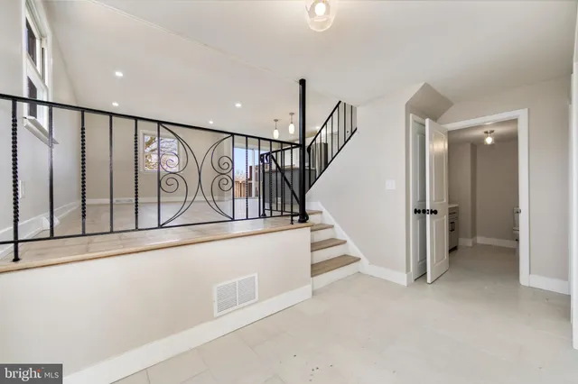 a view of staircase with lots of frames on wall and a window