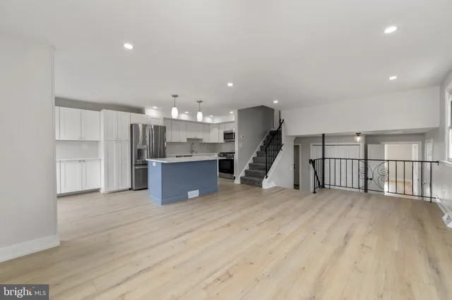 a view of a kitchen with a sink wooden cabinets and a refrigerator