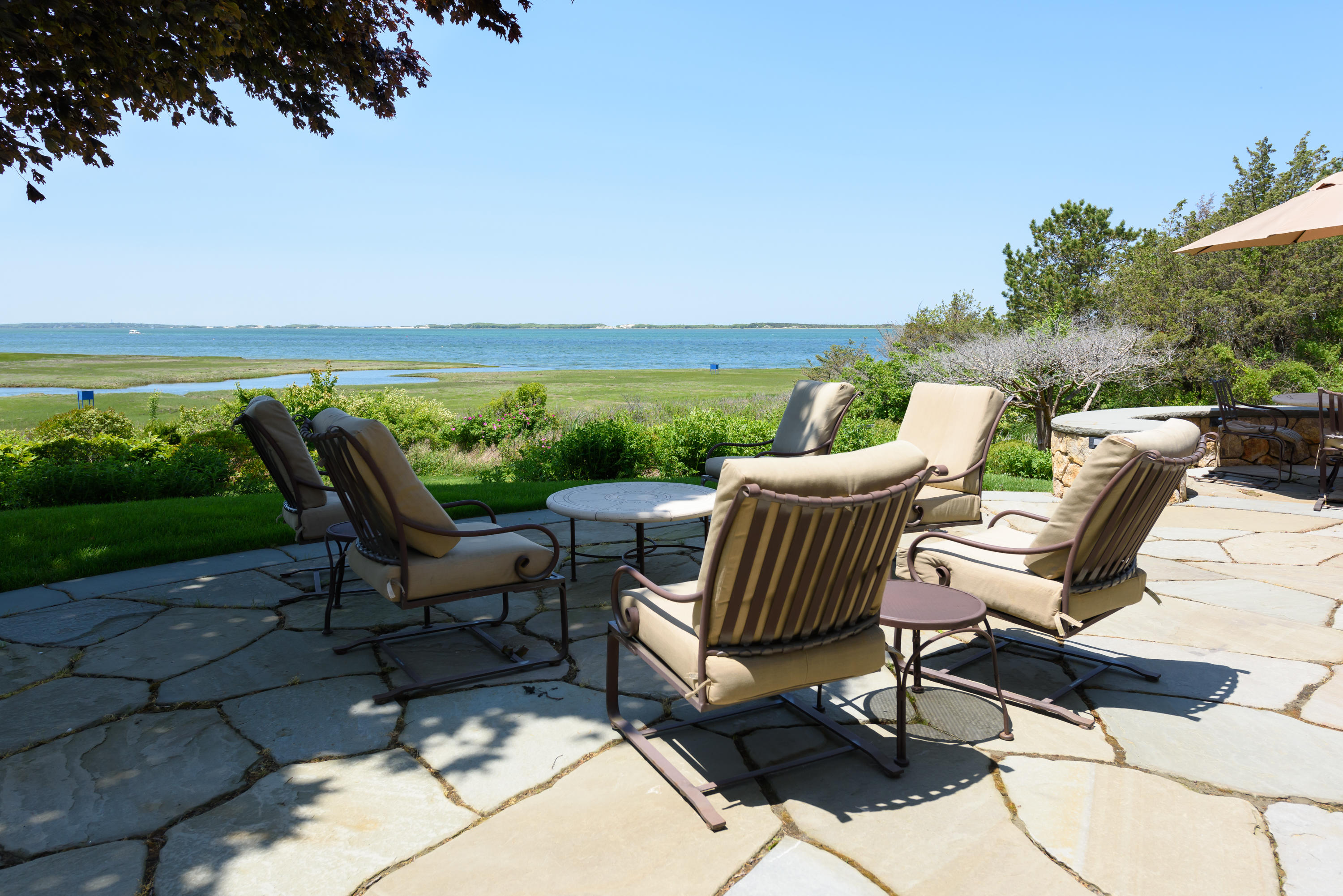 85 Salten Point Road Barnstable, MA 02630 - Photo 31 of 34 a view of a patio with lawn chairs floor to ceiling window and an outdoor seating