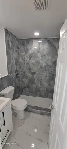a bathroom with a toilet and a shower