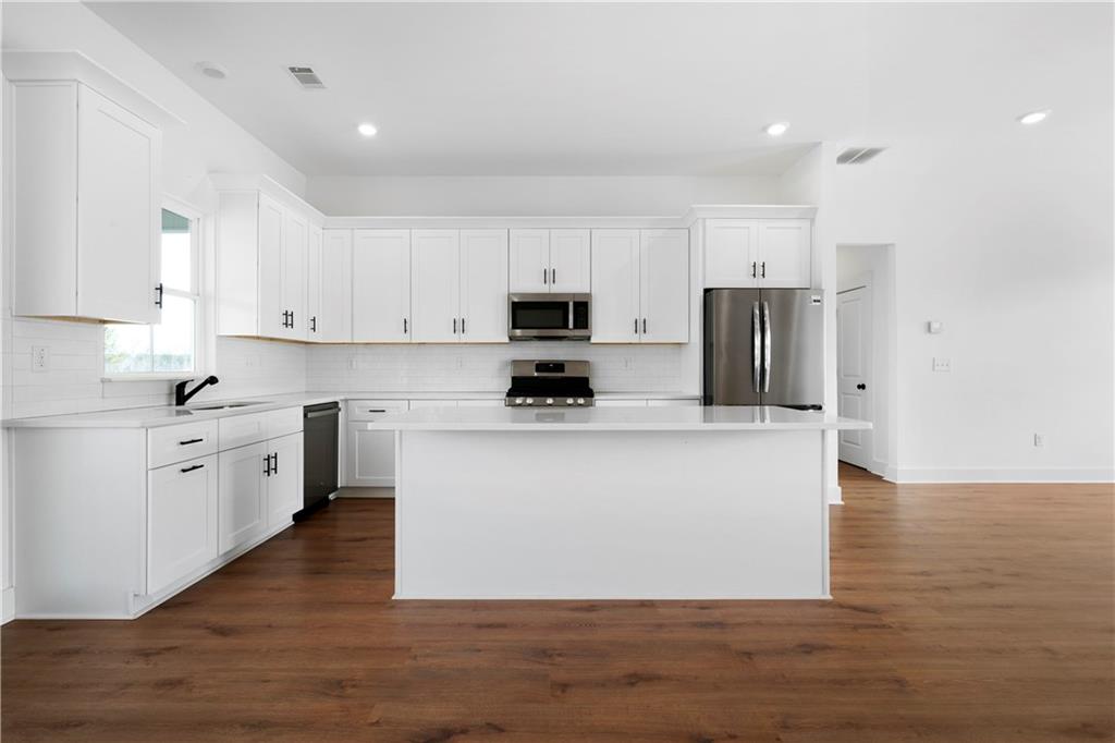 19 Trotters Lane Rome, GA 30165 - Photo 21 of 44 a view of kitchen with stainless steel appliances granite countertop a stove top oven a refrigerator a sink and dishwasher with wooden floor