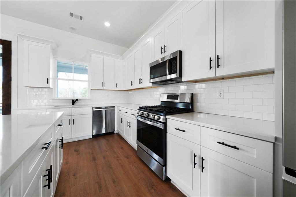 19 Trotters Lane Rome, GA 30165 - Photo 23 of 44 a kitchen with white cabinets stainless steel appliances and sink