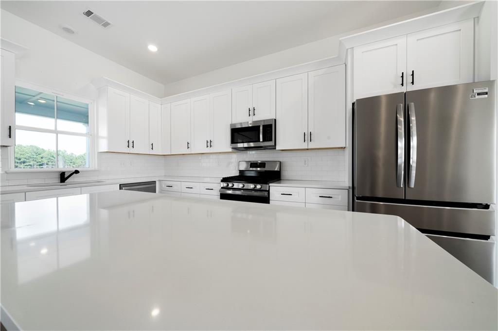 19 Trotters Lane Rome, GA 30165 - Photo 25 of 44 a kitchen with granite countertop a refrigerator and a stove top oven