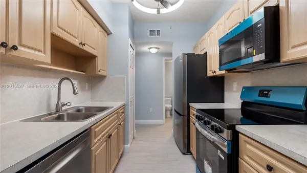 a kitchen with stainless steel appliances a sink a stove and a refrigerator